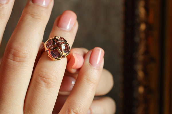 Close-up of a hand wearing a decorative ring with a blurred background
