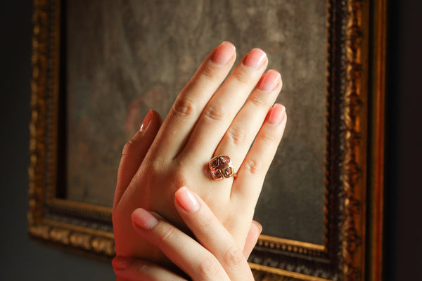 Close-up of a hand wearing a ring with a decorative frame in the background