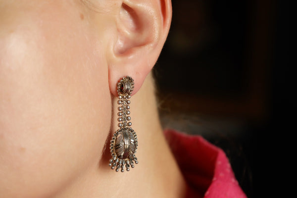 Close-up of an earring worn by a person with a blurred background