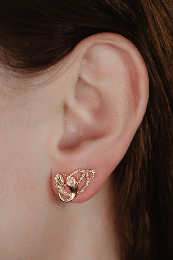 An artisan antique revival pair of solid 14k gold snake stud earrings. These snake earrings are made of pure 14 karat gold and are set with natural diamonds.  These earrings can be worn as a single stud or together as a pair. We have them both in white, rose and yellow gold, so please choose your preferred metal in the variations section.