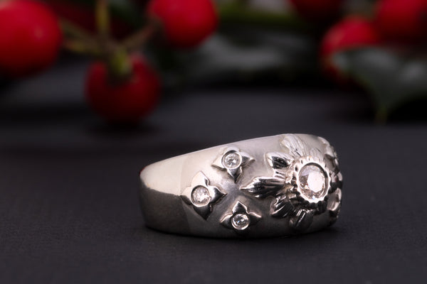 A white gold diamond starburst ring made of solid 18 ct gold and set with 0.35 ct worth of diamonds.  The shank of this celestial ring is rather wide and puffy, the front part is brushed and has a velvet-like gold texture. The celestial centerpiece is set with 7 diamonds.  The central diamond of 0.2 ct is set in an elevated 'star' setting and is surrounded by six smaller stones.