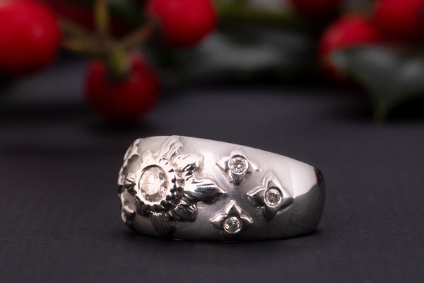 A white gold diamond starburst ring made of solid 18 ct gold and set with 0.35 ct worth of diamonds.  The shank of this celestial ring is rather wide and puffy, the front part is brushed and has a velvet-like gold texture. The celestial centerpiece is set with 7 diamonds.  The central diamond of 0.2 ct is set in an elevated 'star' setting and is surrounded by six smaller stones.