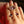 Close-up of a hand wearing a gold ring with purple gemstone on a dark background