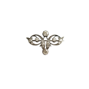 Silver brooch with decorative elements on a white background