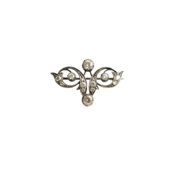 Silver brooch with decorative elements on a white background