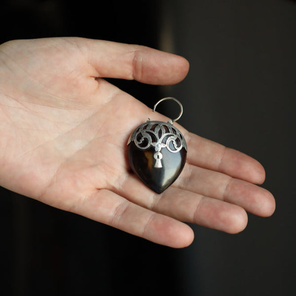 A highly sought for and highly collectible Victorian era British antique lock heart pendant. This unusual large lock charm is made of carved shell and is adorned with silver ornament crowned with a openable padlock.

Graceful body of this antique heart lock is made of carved shell with solid silver fittings. The lock functions perfectly and is beautifuly preserved with very minor surface wear on a rear side (glass loss only, no chips, cracks and dents). The medallion measures 4.5 x 3.5 cm (1.6 x 1.35 inch) 