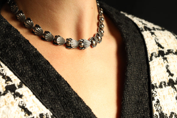 A statement vintage Art Deco necklace by Hermann Siersbøl, Denmark. Dating circa late 1940s, this flower necklace is handmade from solid sterling silver and is 18 inches long. The necklace has a stunning Art Deco style floral profile with a deliberate reverse inner side. The chain is 40 cm or 16 inches long and has an extra security chain to protect it from falling.

A beautiful example of Danish 1940s jewelry, this handmade designer chain will make an amazind daily eye-catcher. This chain necklace has a ha