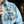 Person wearing a denim jacket with various pins, including a 'Star Wars' pin, in an indoor setting.