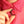 Person wearing a pink shirt with a hand holding a decorative brooch.