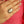Hand wearing a large ring with a clear stone against a pink background