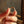 Gold ring held between fingers with a blurred background