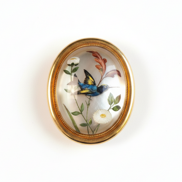 Antique Bird brooch with floral and butterfly design in a gold frame on a white background