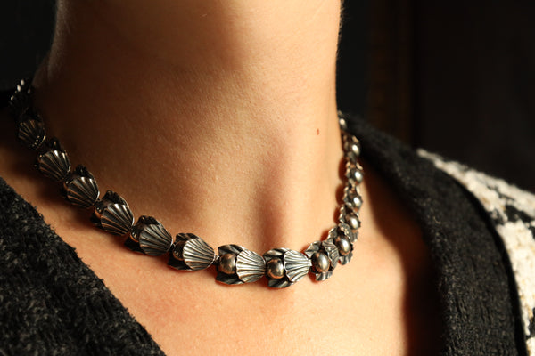 A statement vintage Art Deco necklace by Hermann Siersbøl, Denmark. Dating circa late 1940s, this flower necklace is handmade from solid sterling silver and is 18 inches long. The necklace has a stunning Art Deco style floral profile with a deliberate reverse inner side. The chain is 40 cm or 16 inches long and has an extra security chain to protect it from falling.

A beautiful example of Danish 1940s jewelry, this handmade designer chain will make an amazind daily eye-catcher. This chain necklace has a ha