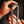 Silver bracelet held by hands against a dark background