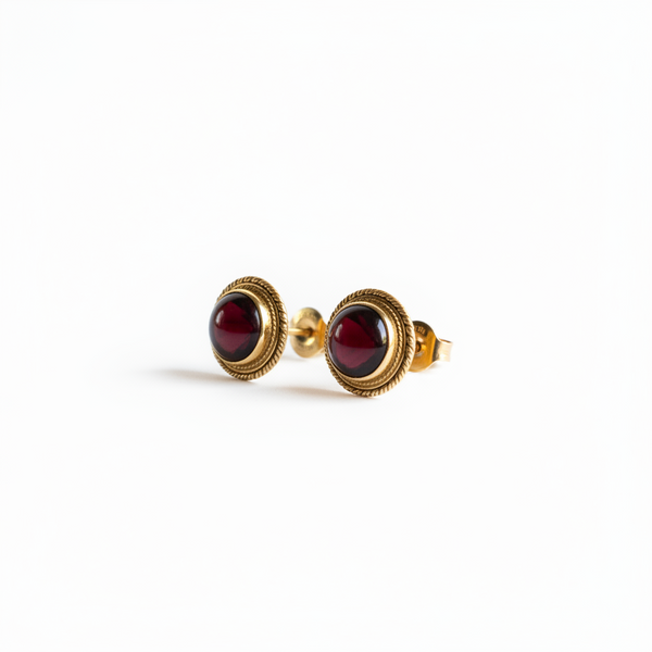 Pair of earrings with green gemstones and gold accents on a white background
