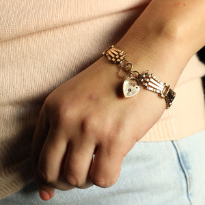 Close-up of a wrist wearing a bracelet with charms against a dark background