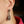 Close-up of an earring worn by a person with a blurred background