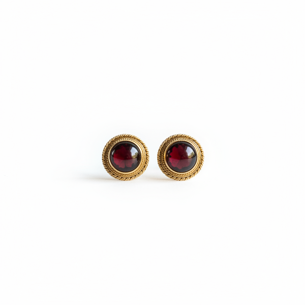Pair of earrings with green gemstones and gold accents on a white background