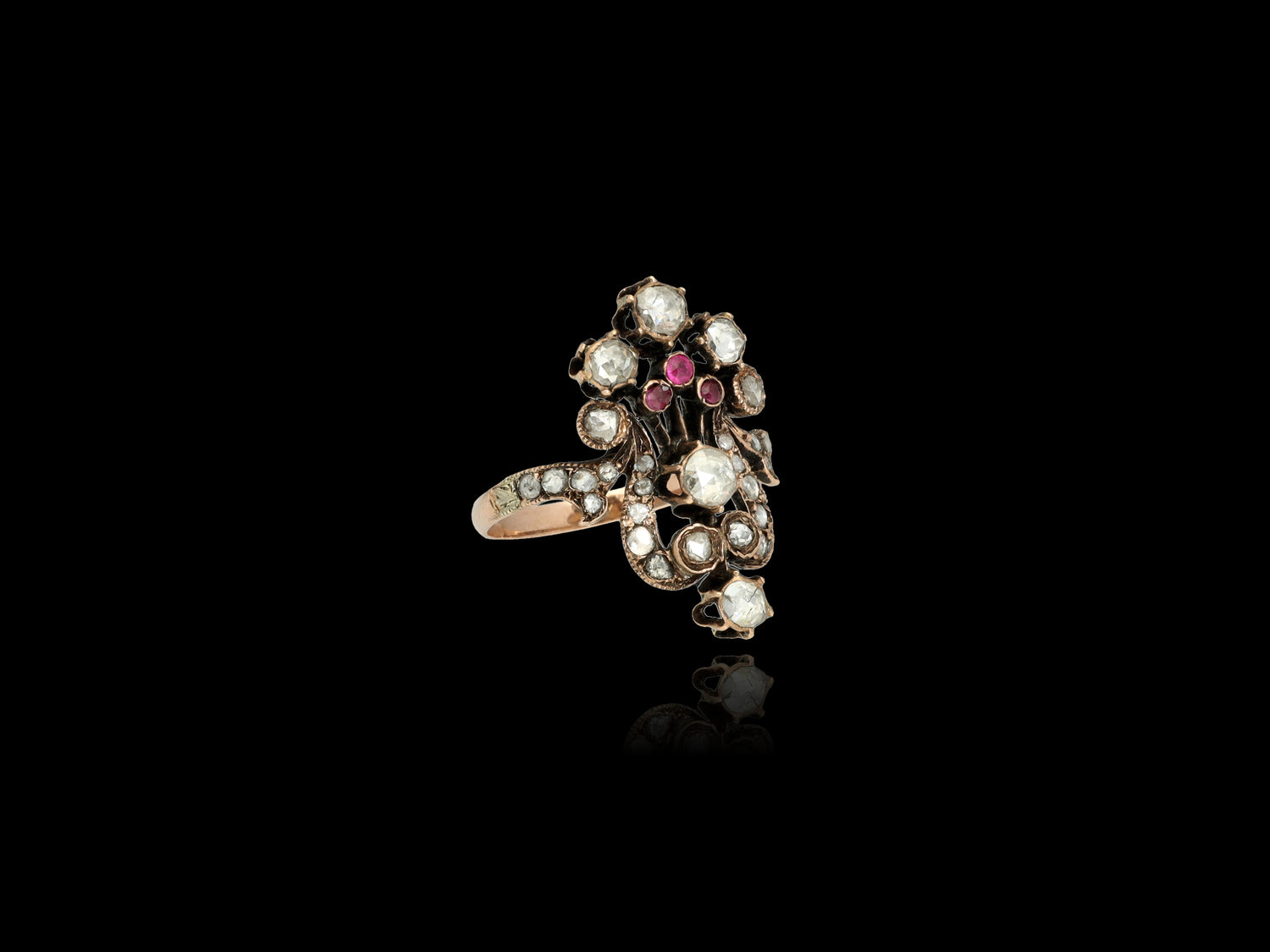  A statement ring that evokes the spirit of romance, this antique beauty features 29 old Rose-cut diamonds forming a lovely flower bouquet along with three 0.05 CT natural rubies. The diamonds are preserved in a superb state with larger 7 stones.