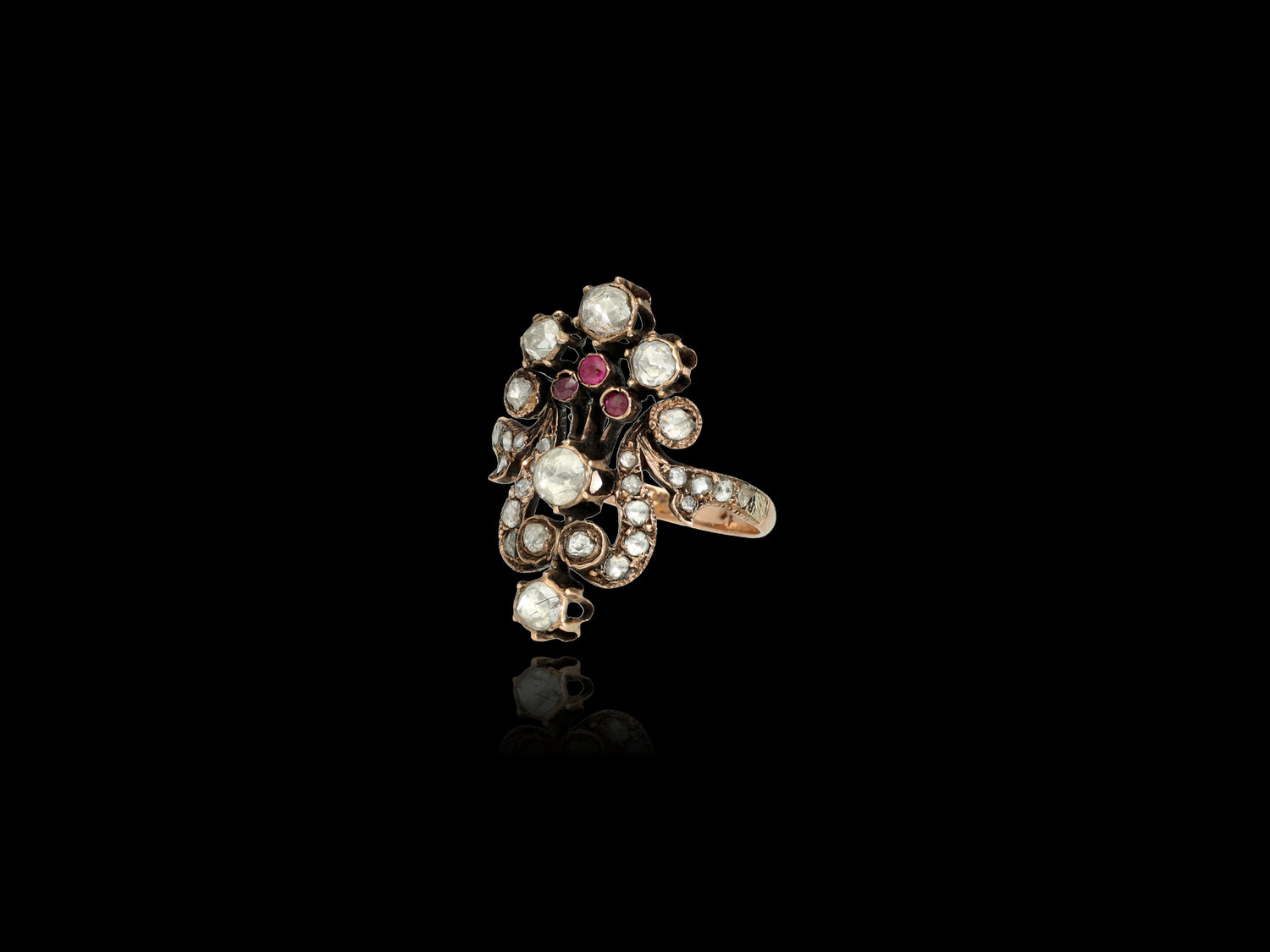  A statement ring that evokes the spirit of romance, this antique beauty features 29 old Rose-cut diamonds forming a lovely flower bouquet along with three 0.05 CT natural rubies. The diamonds are preserved in a superb state with larger 7 stones.