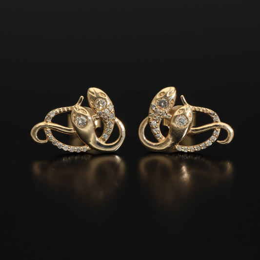 An artisan antique revival pair of solid 14k gold snake stud earrings. These snake earrings are made of pure 14 karat gold and are set with natural diamonds.  These earrings can be worn as a single stud or together as a pair. We have them both in white, rose and yellow gold, so please choose your preferred metal in the variations section.