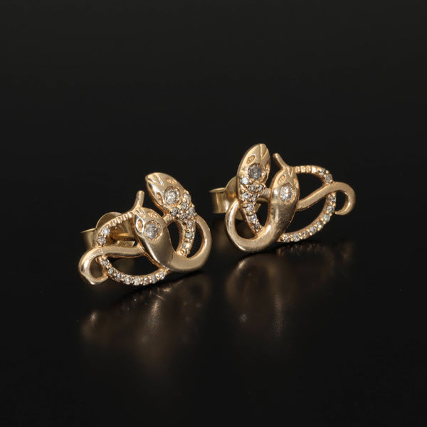 An artisan antique revival pair of solid 14k gold snake stud earrings. These snake earrings are made of pure 14 karat gold and are set with natural diamonds.  These earrings can be worn as a single stud or together as a pair. We have them both in white, rose and yellow gold, so please choose your preferred metal in the variations section.